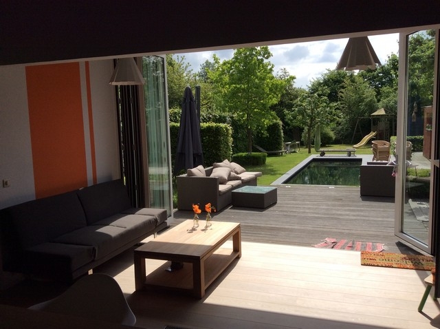 Black aluminum bifold glass doors fully opened connecting indoor living space to outdoor patio area