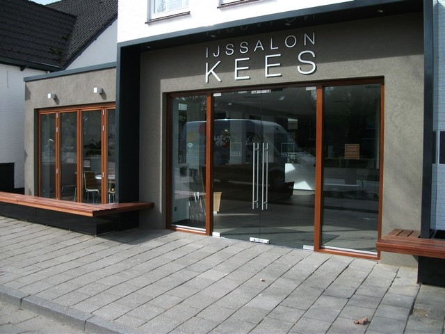 Black aluminum bifold glass doors fully opened connecting indoor living space to outdoor patio area