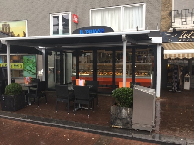 Black aluminum bifold glass doors fully opened connecting indoor living space to outdoor patio area
