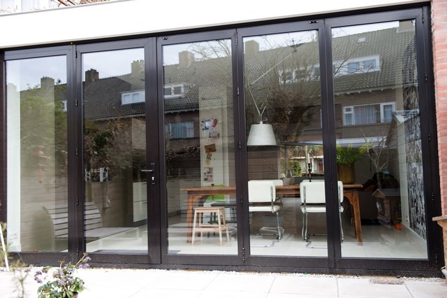 Black aluminum bifold glass doors fully opened connecting indoor living space to outdoor patio area