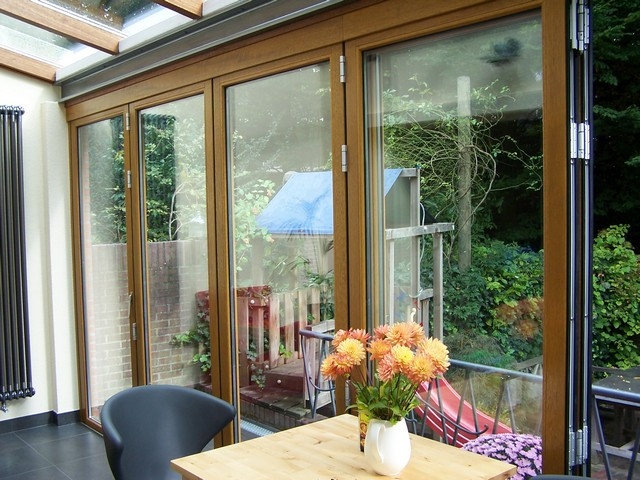 Black aluminum bifold glass doors fully opened connecting indoor living space to outdoor patio area