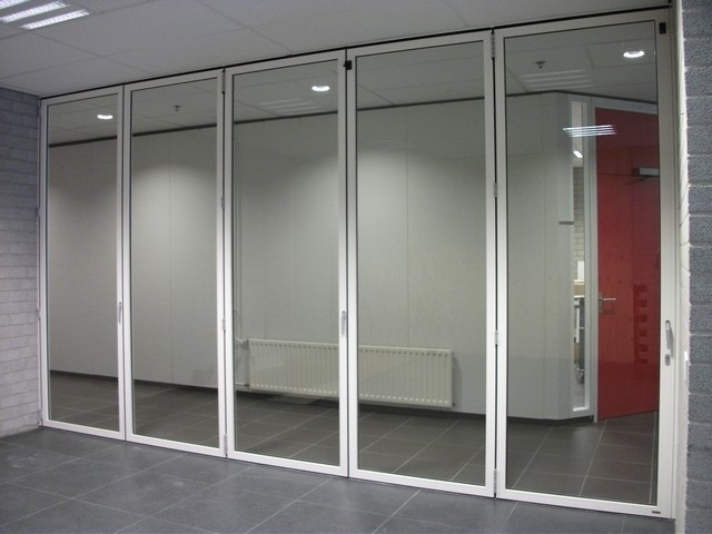 Black aluminum bifold glass doors fully opened connecting indoor living space to outdoor patio area