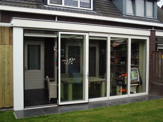 Black aluminum bifold glass doors fully opened connecting indoor living space to outdoor patio area