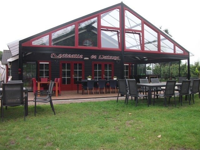 Black aluminum bifold glass doors fully opened connecting indoor living space to outdoor patio area