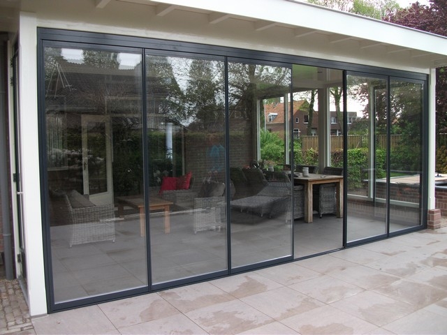 Black aluminum bifold glass doors fully opened connecting indoor living space to outdoor patio area