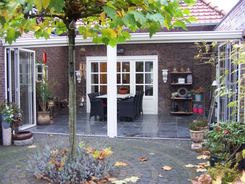Black aluminum bifold glass doors fully opened connecting indoor living space to outdoor patio area