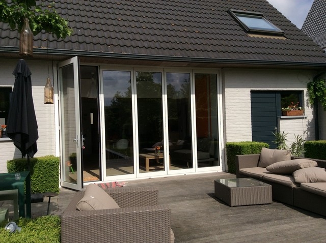 Black aluminum bifold glass doors fully opened connecting indoor living space to outdoor patio area