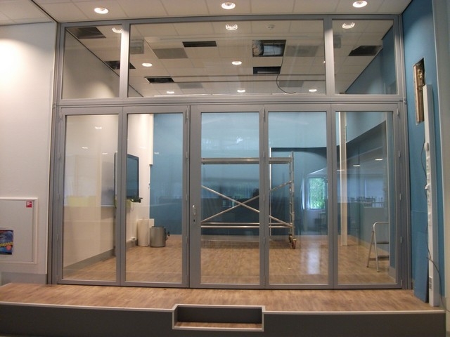 Black aluminum bifold glass doors fully opened connecting indoor living space to outdoor patio area