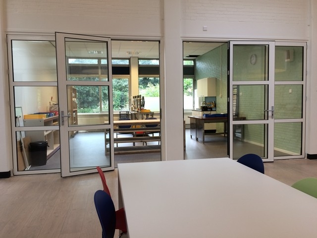 Black aluminum bifold glass doors fully opened connecting indoor living space to outdoor patio area