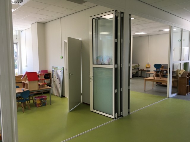 Black aluminum bifold glass doors fully opened connecting indoor living space to outdoor patio area