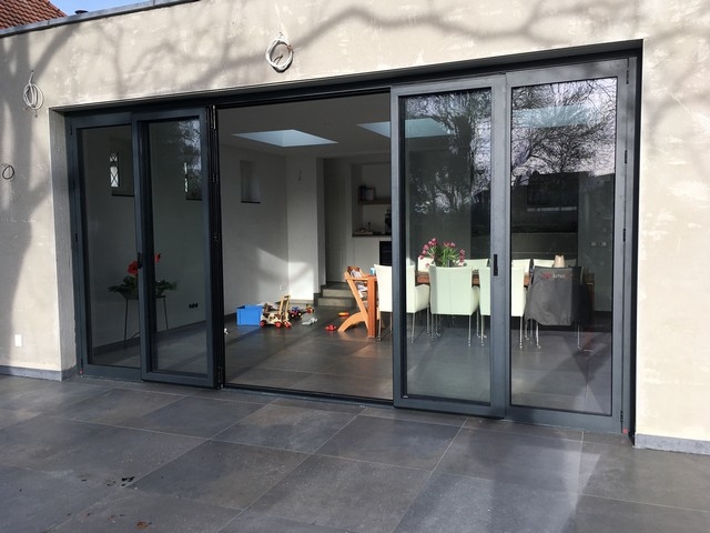 Black aluminum bifold glass doors fully opened connecting indoor living space to outdoor patio area