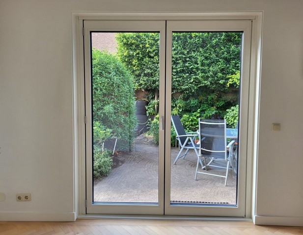 Black aluminum bifold glass doors fully opened connecting indoor living space to outdoor patio area