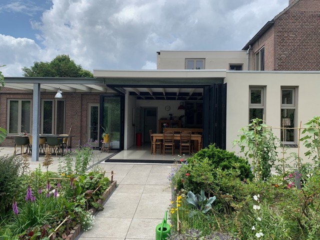 Black aluminum bifold glass doors fully opened connecting indoor living space to outdoor patio area