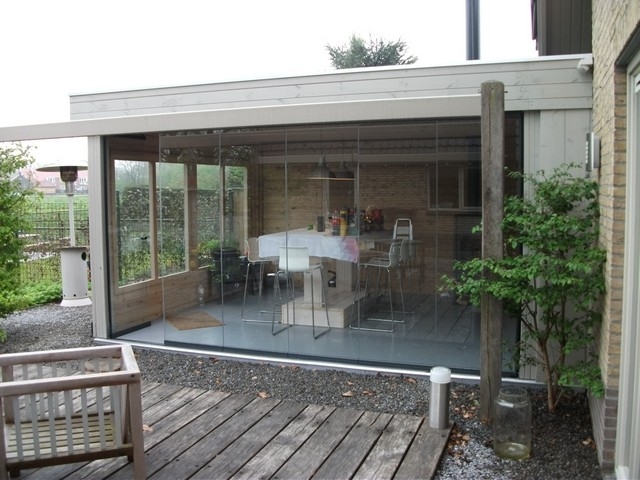 Black aluminum bifold glass doors fully opened connecting indoor living space to outdoor patio area