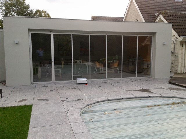 Black aluminum bifold glass doors fully opened connecting indoor living space to outdoor patio area