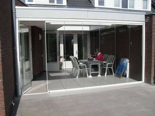 Black aluminum bifold glass doors fully opened connecting indoor living space to outdoor patio area