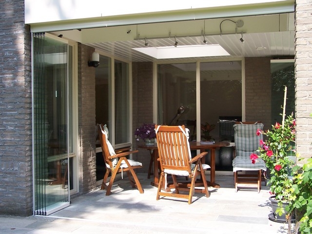 Black aluminum bifold glass doors fully opened connecting indoor living space to outdoor patio area