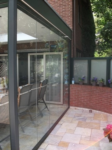 Black aluminum bifold glass doors fully opened connecting indoor living space to outdoor patio area