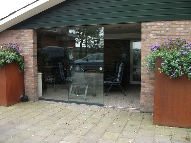 Black aluminum bifold glass doors fully opened connecting indoor living space to outdoor patio area