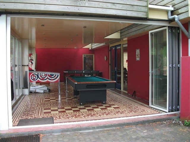 Black aluminum bifold glass doors fully opened connecting indoor living space to outdoor patio area
