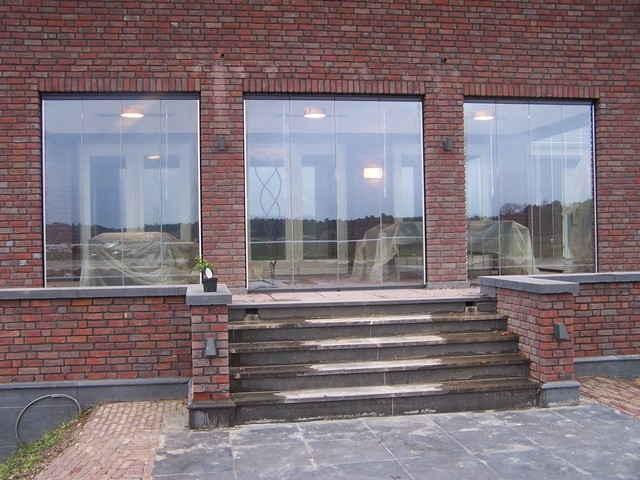 Black aluminum bifold glass doors fully opened connecting indoor living space to outdoor patio area