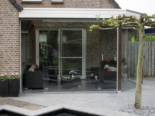 Black aluminum bifold glass doors fully opened connecting indoor living space to outdoor patio area