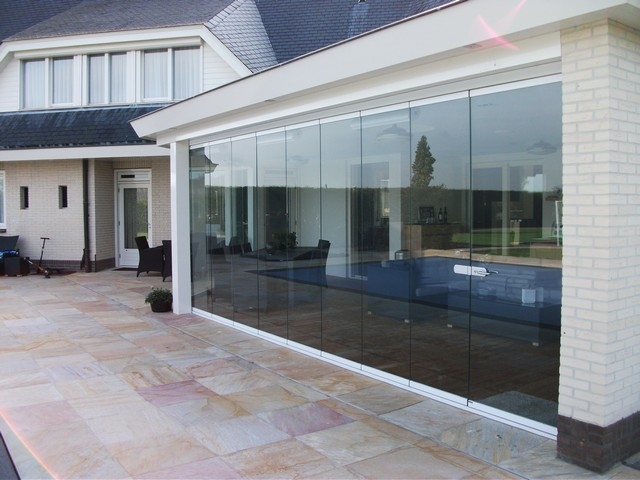 Black aluminum bifold glass doors fully opened connecting indoor living space to outdoor patio area