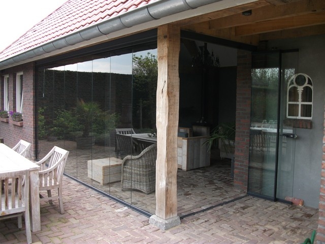 Black aluminum bifold glass doors fully opened connecting indoor living space to outdoor patio area