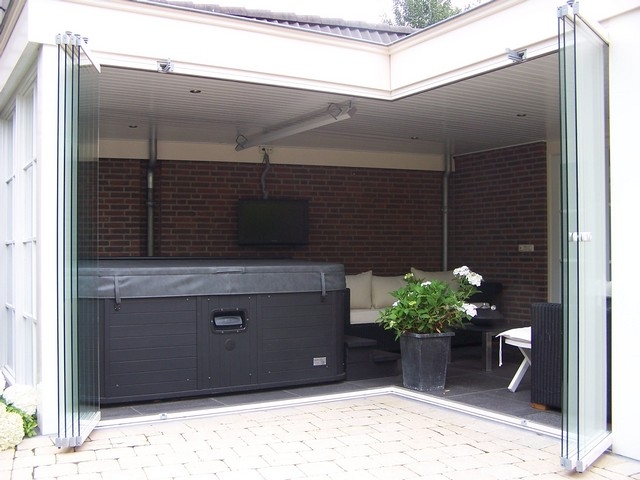 Black aluminum bifold glass doors fully opened connecting indoor living space to outdoor patio area