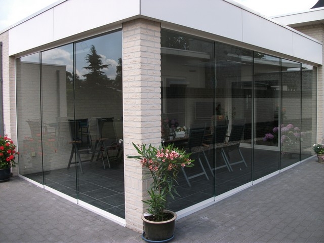 Black aluminum bifold glass doors fully opened connecting indoor living space to outdoor patio area