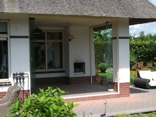 Black aluminum bifold glass doors fully opened connecting indoor living space to outdoor patio area