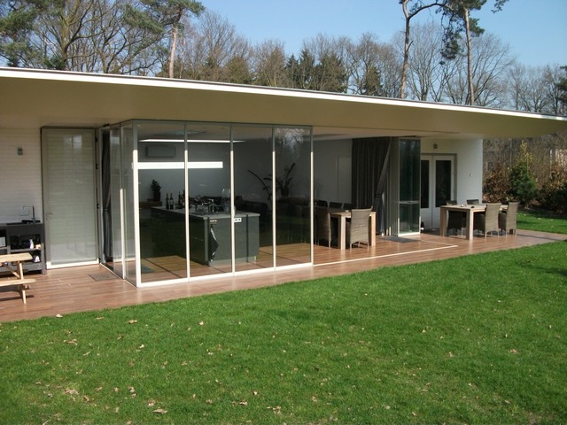 Black aluminum bifold glass doors fully opened connecting indoor living space to outdoor patio area