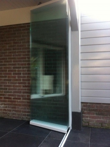 Black aluminum bifold glass doors fully opened connecting indoor living space to outdoor patio area