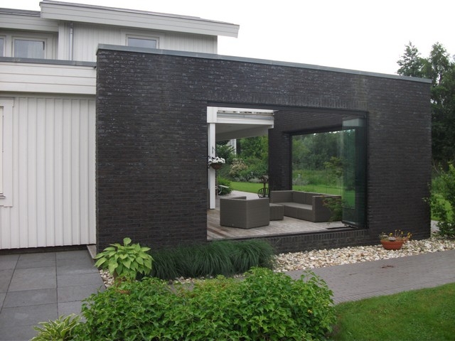 Black aluminum bifold glass doors fully opened connecting indoor living space to outdoor patio area