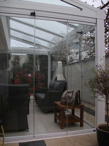 Black aluminum bifold glass doors fully opened connecting indoor living space to outdoor patio area